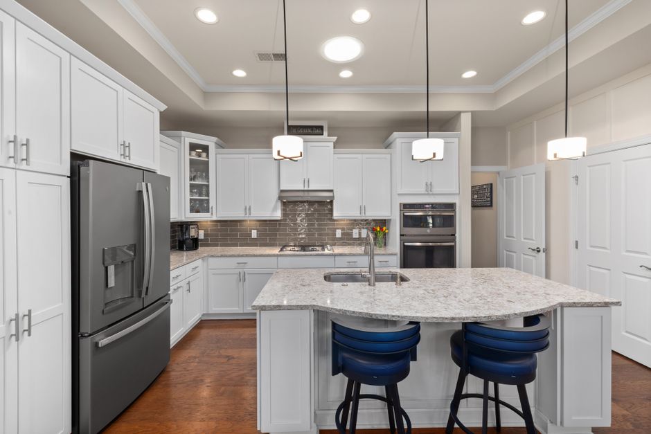 Family command center wall in kitchen with calendar, chalkboard, and warm task lighting